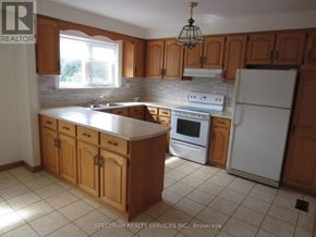 Toronto (Brookhaven-Amesbury) apartment for rent - A kitchen with wooden cabinets and a white refrigerator.