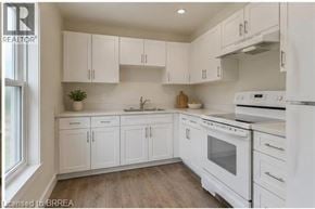 Brantford apartment for rent - A kitchen with white cabinets and appliances.