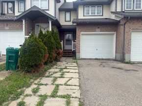 Kitchener townhouse for rent - A house with a garage and a driveway in front of it.