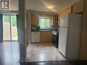Kitchener townhouse for rent - A kitchen with a refrigerator, sink, and cabinets.