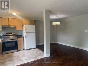 Kitchener townhouse for rent - A kitchen with a white refrigerator and wooden cabinets.