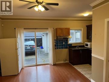 Burnaby apartment for rent - A kitchen with a white fridge and wooden floors.
