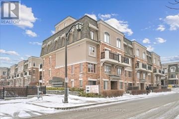 Oakville (Wm Westmount) townhouse for rent - A large brick building with a black gate in front.
