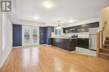 Oakville (Wm Westmount) townhouse for rent - A spacious kitchen with dark wood cabinets and a white refrigerator.