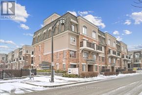 Oakville (Wm Westmount) townhouse for rent - A large brick building with a black gate in front.