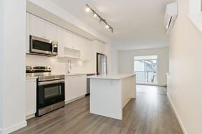 Surrey townhouse for rent - A kitchen with white cabinets and a black oven.