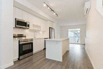 Surrey townhouse for rent - A kitchen with white cabinets and a black oven.