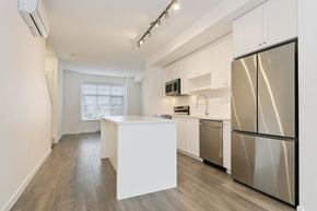 Surrey townhouse for rent - A kitchen with a white island and stainless steel appliances.