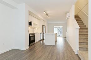 Surrey townhouse for rent - A spacious living room with a staircase leading to the upper floor.