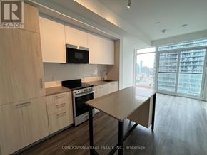Toronto (Church-Yonge Corridor) condo for rent - A kitchen with wooden cabinets and a microwave above the stove.