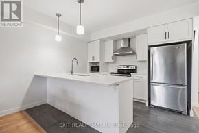 The Nation fourplex for rent - A modern kitchen with white cabinets and stainless steel appliances.