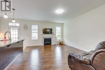 Oakville (Go Glenorchy) townhouse for rent - A living room with a leather couch and a fireplace.