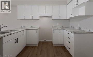 Stratford townhouse for rent - A kitchen with white cabinets and marble countertops.