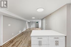 St. Catharines (Carlton/Bunting) apartment for rent - A spacious room with a long white counter and wooden flooring.