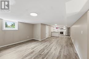 St. Catharines (Carlton/Bunting) apartment for rent - A spacious room with wood flooring and a large window.