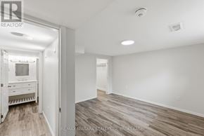 St. Catharines (Carlton/Bunting) apartment for rent - A spacious room with wooden flooring and white walls.