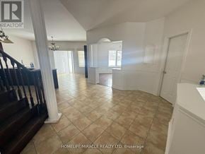 Barrie (Ardagh) apartment for rent - A spacious room with tiled flooring and a staircase on the left side.
