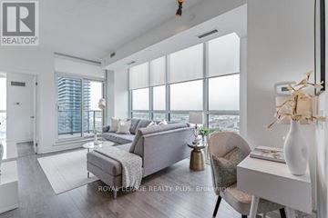 Toronto (Islington-City Centre West) condo for rent - A modern living room with a grey sofa and a large window.