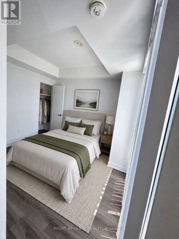 Mississauga (City Centre) condo for rent - A bedroom with a bed and a painting on the wall.