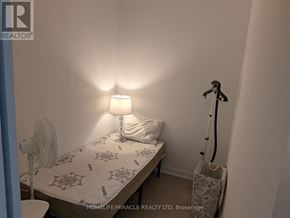 Mississauga (City Centre) condo for rent - A bedroom with a bed, a fan, a lamp, and a trash can.