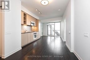 Toronto (Niagara) condo for rent - A spacious kitchen with wooden floors and white walls.