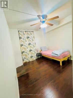 Guelph (Willow West/Sugarbush/West Acres) condo for rent - A bedroom with a bed, a ceiling fan, and a window with a floral curtain.