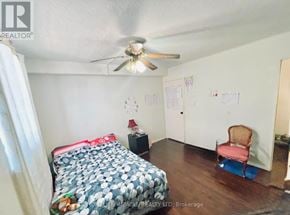 Guelph (Willow West/Sugarbush/West Acres) condo for rent - A bedroom with a bed, chair, and ceiling fan.