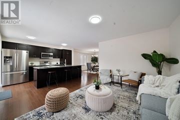 Cambridge apartment for rent - A modern living room with a grey sofa and a round white ottoman.