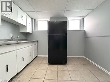 Windsor apartment for rent - A black refrigerator in a kitchen with white cabinets.