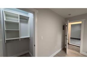 Langley apartment for rent - A white pantry with open shelves and a doorway leading to a bathroom.