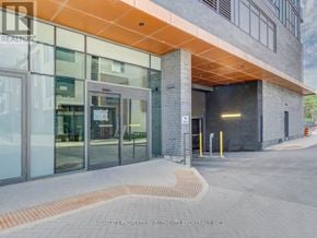 Vaughan (Concord) condo for rent - The entrance to a building with glass doors and a brick walkway.