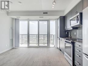 Vaughan (Concord) condo for rent - A modern kitchen with a view of the city through the sliding glass doors.
