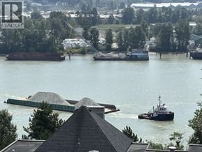 New Westminster apartment for rent - A barge carrying a load of gravel is docked in a river.