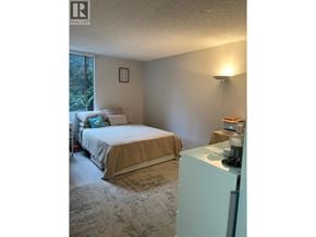 North Vancouver apartment for rent - A bedroom with a bed, nightstand, and lamp.