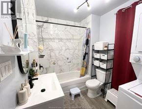 Windsor apartment for rent - A white bathroom with a marble tile shower and a red shower curtain.