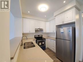Toronto (Clairlea-Birchmount) townhouse for rent - A kitchen with a stainless steel refrigerator, sink, and cabinets.