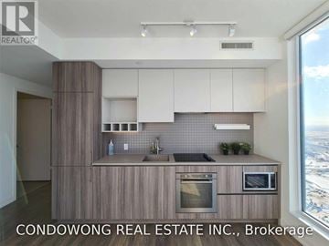 Vaughan (Vaughan Corporate Centre) condo for rent - A kitchen with wooden cabinets and a large window overlooking a cityscape.