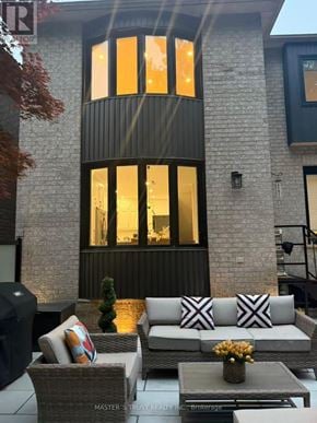 Oakville (Jc Joshua Creek) townhouse for rent - A patio with a couch, chairs, and a table with a vase of flowers.