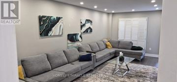 Mississauga (Lisgar) apartment for rent - A living room with a grey sofa and a glass coffee table.