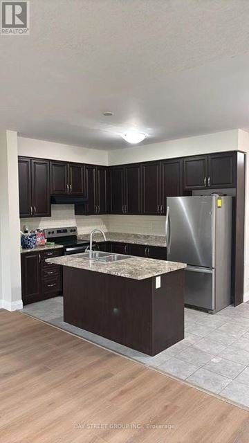 Niagara Falls (Brown) apartment for rent - A kitchen with dark wood cabinets and a stainless steel refrigerator.