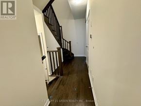 Kitchener townhouse for rent - A hallway with a staircase and a door on the right side.