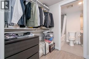 Vancouver apartment for rent - A closet with clothes hanging and a toilet in the background.