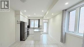 Pickering townhouse for rent - A spacious kitchen with white cabinets and a refrigerator.