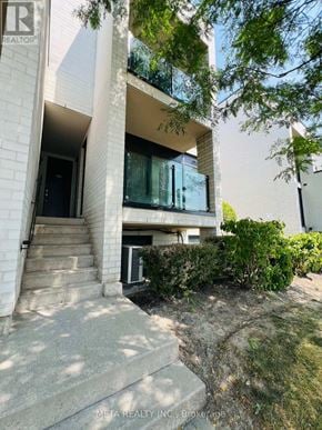 Toronto (Willowridge-Martingrove-Richview) townhouse for rent - A modern building with a balcony and a glass door.