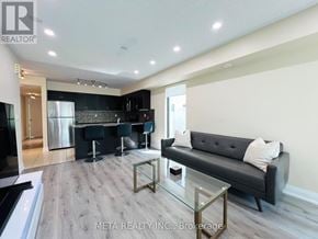 Toronto (Willowridge-Martingrove-Richview) townhouse for rent - A modern kitchen with a black couch and a glass table.