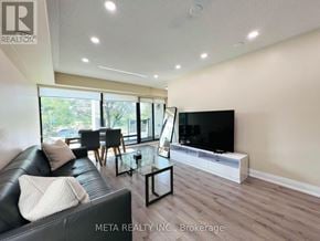 Toronto (Willowridge-Martingrove-Richview) townhouse for rent - A living room with a black leather couch and a flat screen TV.