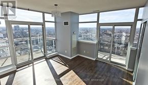 Brampton (Queen Street Corridor) condo for rent - A large, empty room with floor-to-ceiling windows overlooking a cityscape.
