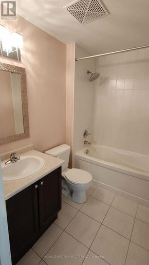 Brampton (Queen Street Corridor) condo for rent - A white toilet sits next to a sink in a bathroom.