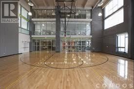 Mississauga (City Centre) condo for rent - A basketball court with a wooden floor and a glass wall in the background.