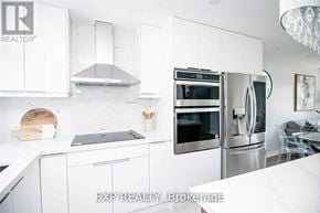 Oakville (Wo West) apartment for rent - A modern kitchen with white cabinets and stainless steel appliances.